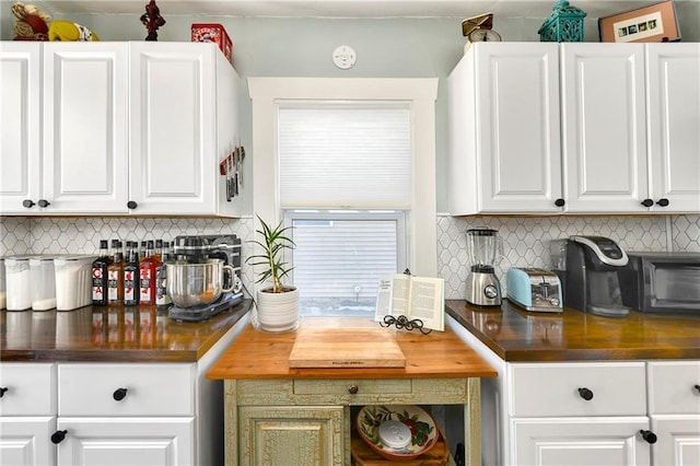 interior space featuring tasteful backsplash, butcher block counters, and white cabinets