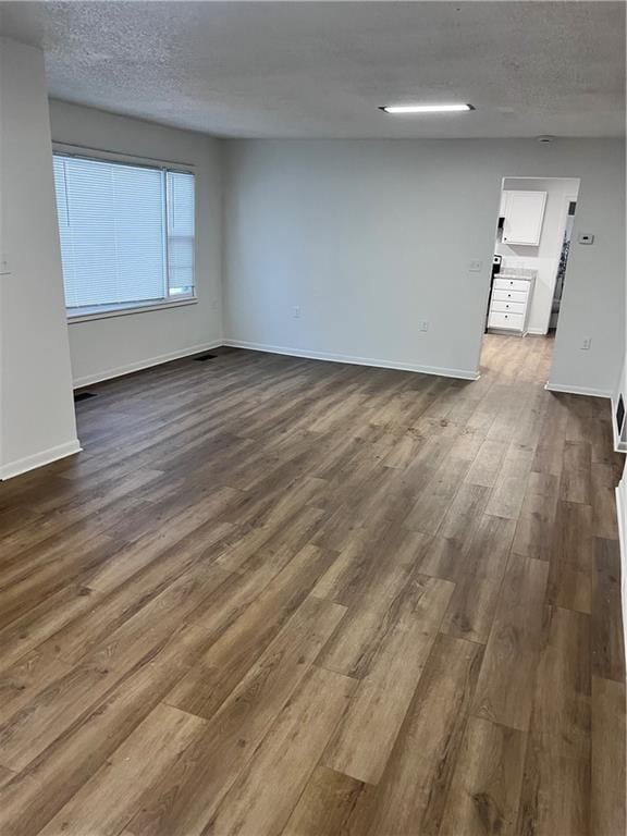 spare room featuring hardwood / wood-style flooring and a textured ceiling