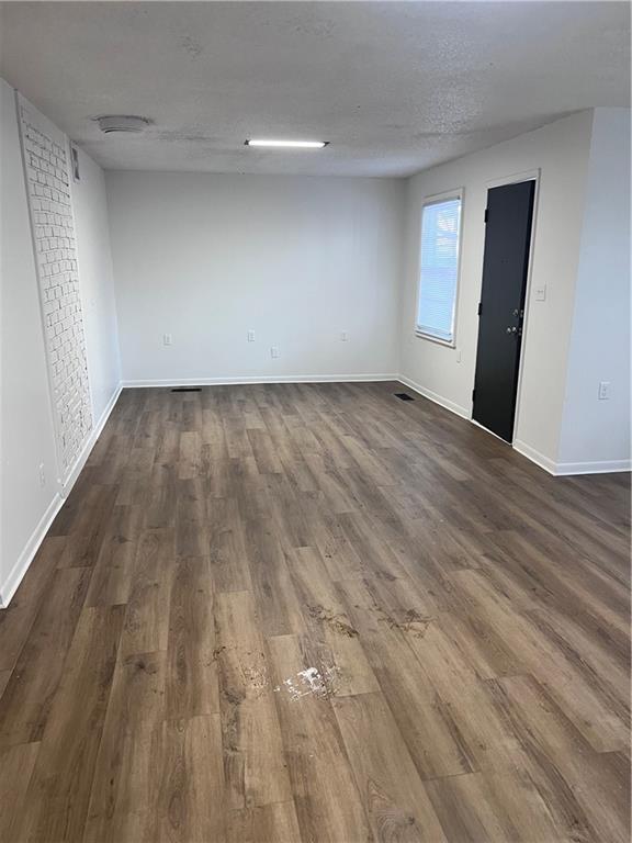 spare room with dark hardwood / wood-style floors and a textured ceiling