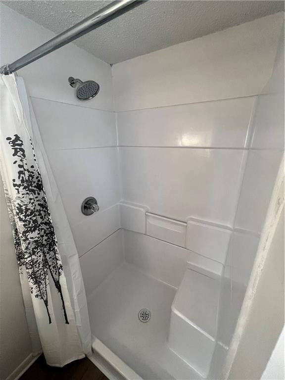 bathroom featuring curtained shower and a textured ceiling