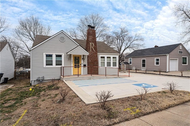 back of property featuring a patio, a garage, and an outbuilding