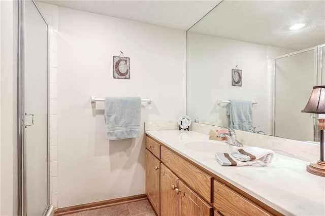 bathroom with tile patterned flooring, vanity, and an enclosed shower