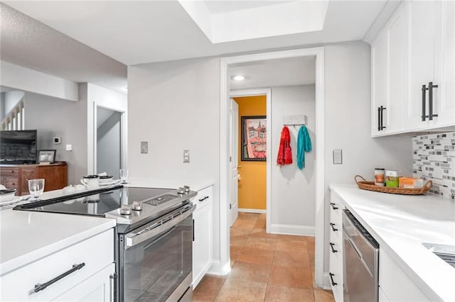 kitchen featuring white cabinetry, stainless steel appliances, tasteful backsplash, and light tile patterned floors