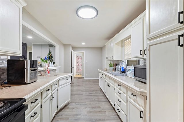 6133 Swope Pkwy, Kansas City, MO 64132 - kitchen with white cabinetry, sink, and light wood-type flooring