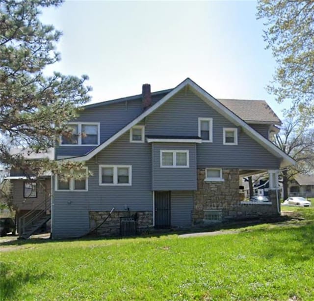 rear view of house featuring a lawn