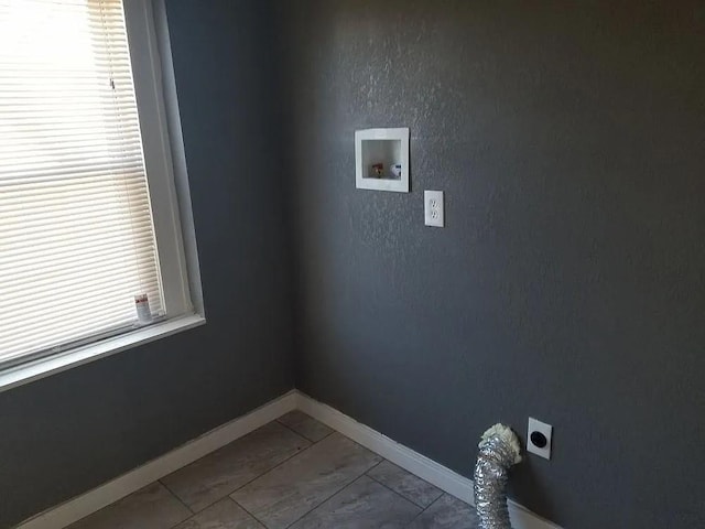 laundry area with light tile patterned floors, hookup for a washing machine, and hookup for an electric dryer