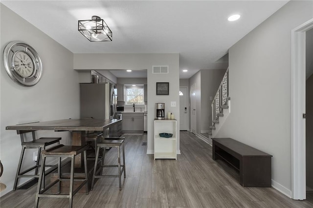 dining room with sink, hardwood / wood-style floors, and a chandelier