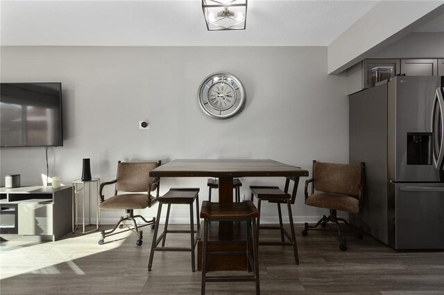 dining area with baseboards and wood finished floors