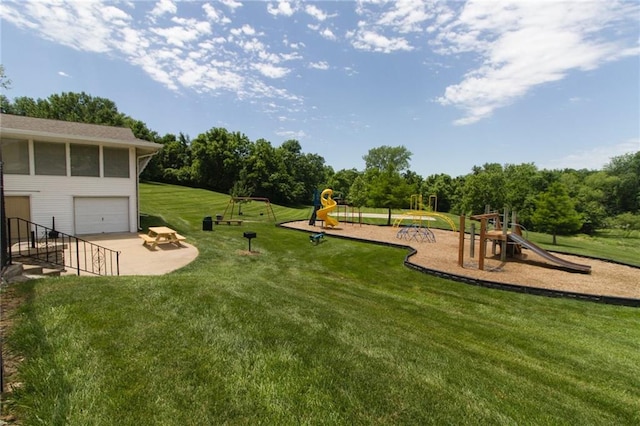 view of yard featuring playground community and an attached garage