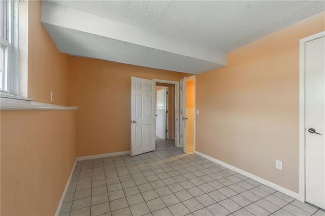 tiled spare room with a textured ceiling