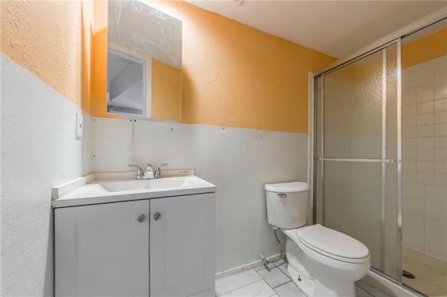 bathroom with tile patterned flooring, vanity, an enclosed shower, and toilet