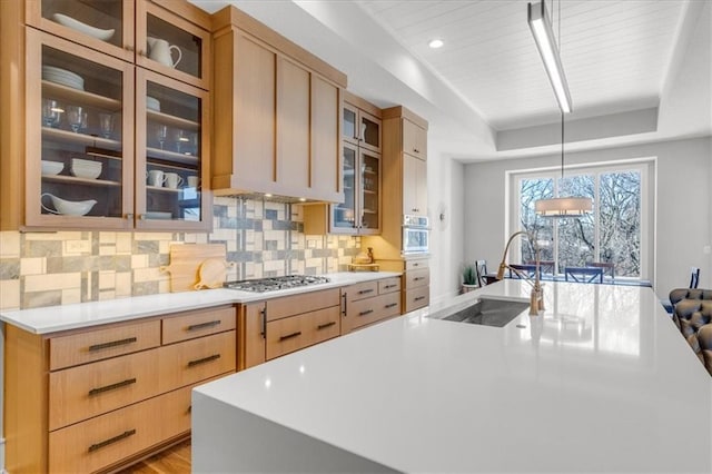 kitchen featuring sink, hanging light fixtures, a tray ceiling, stainless steel appliances, and light brown cabinets