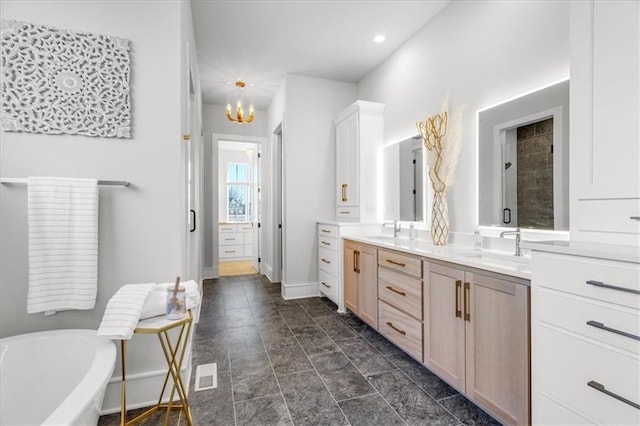 bathroom with vanity, a tub, and an inviting chandelier