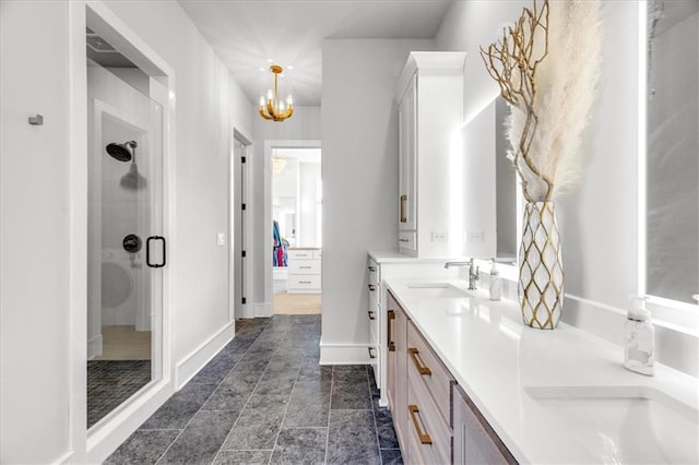 bathroom featuring vanity, a notable chandelier, and a shower with shower door