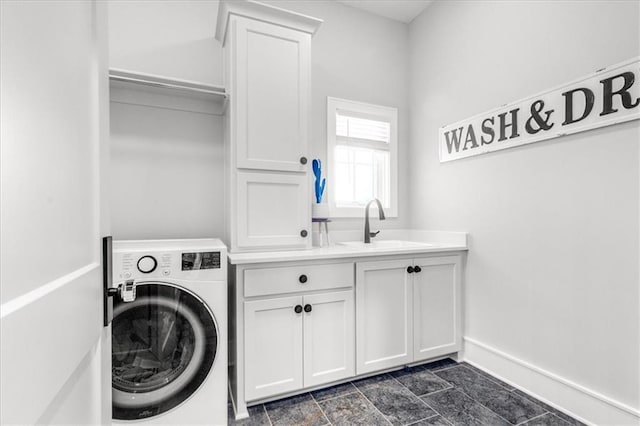 clothes washing area featuring sink, washer / dryer, and cabinets