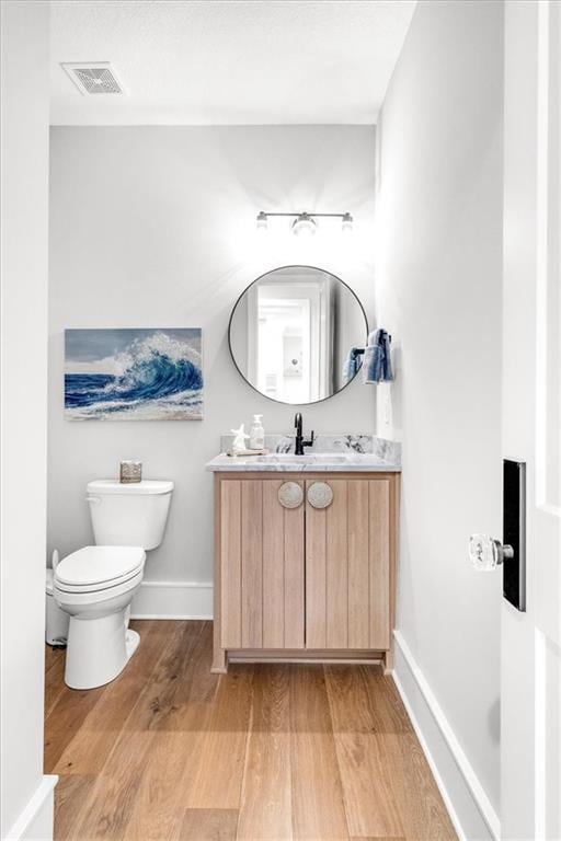 bathroom with vanity, hardwood / wood-style flooring, and toilet