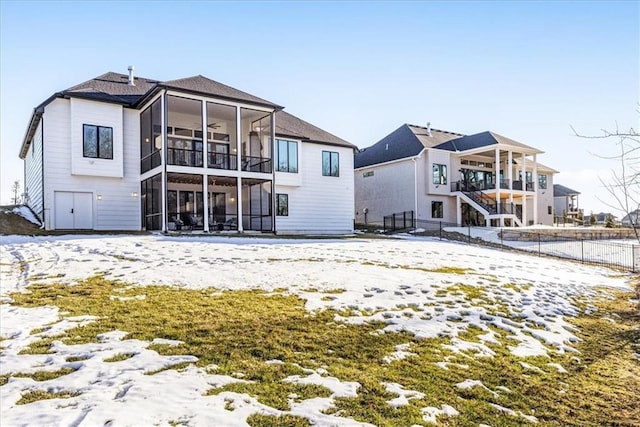 snow covered house featuring ceiling fan