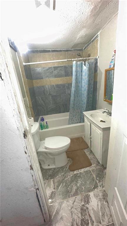 full bathroom featuring vanity, shower / bath combination with curtain, a textured ceiling, and toilet