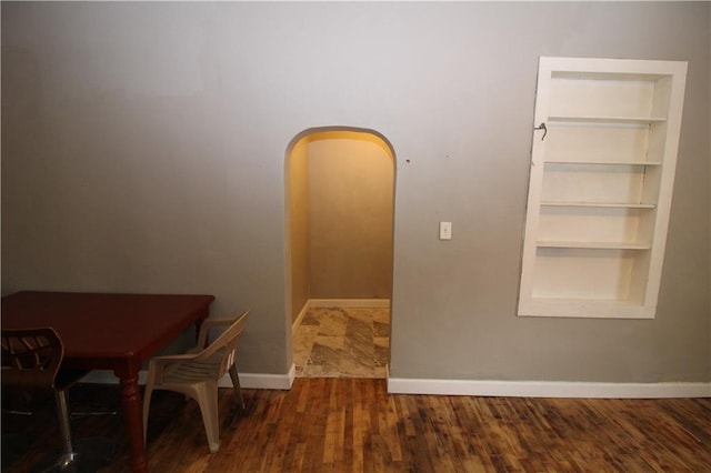 809 S 19th St, Saint Joseph, MO 64507 - dining space featuring baseboards, built in shelves, wood finished floors, and arched walkways