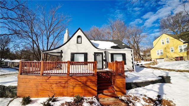 snow covered rear of property featuring a wooden deck