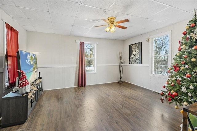 interior space with a drop ceiling, dark wood-type flooring, and ceiling fan