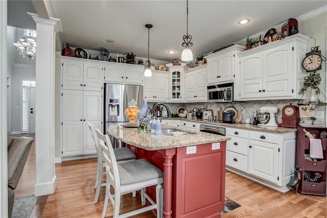 kitchen with white cabinetry, crown molding, appliances with stainless steel finishes, and a sink