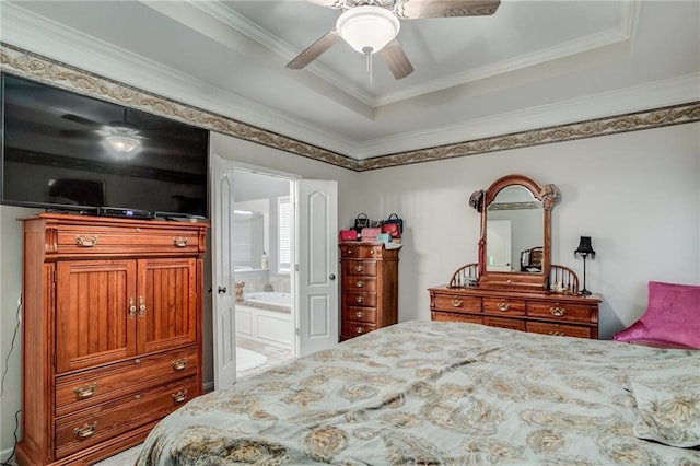 bedroom with a raised ceiling, connected bathroom, a ceiling fan, and ornamental molding