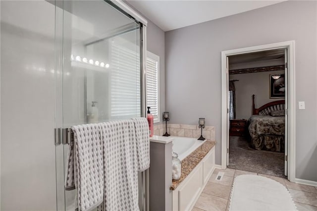 ensuite bathroom featuring a stall shower, baseboards, a garden tub, and ensuite bath