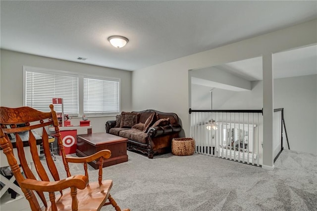 carpeted living area with visible vents and a textured ceiling