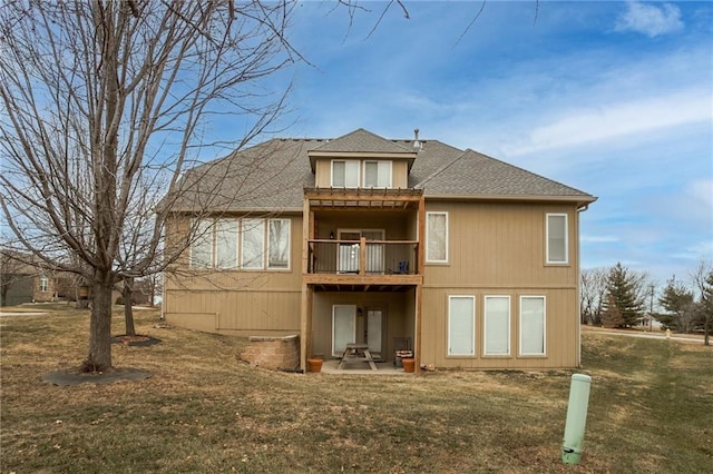 back of house featuring a patio area, a lawn, and a shingled roof