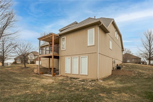 rear view of house with a yard, cooling unit, a pergola, and roof with shingles