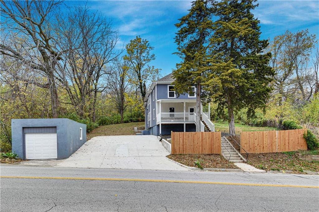 view of front of home featuring a garage, an outdoor structure, and covered porch