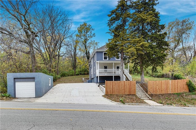 view of front of home featuring a garage, an outdoor structure, and covered porch