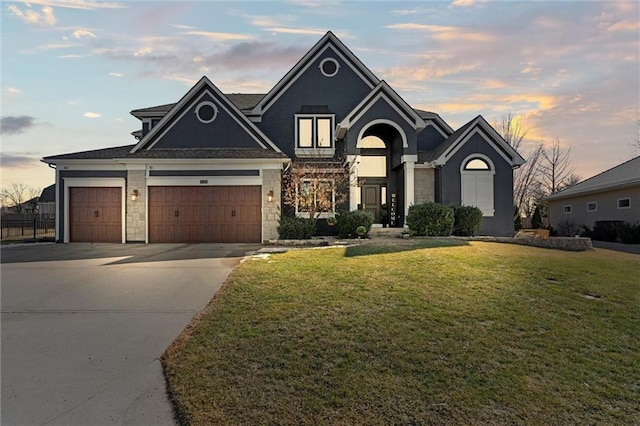 view of front facade featuring concrete driveway, a front lawn, an attached garage, and stone siding