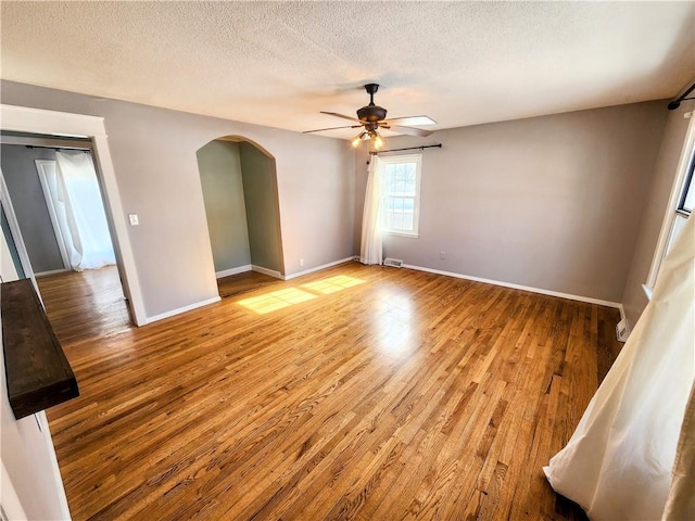 empty room featuring ceiling fan, wood-type flooring, and a textured ceiling