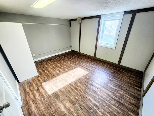 unfurnished bedroom with dark hardwood / wood-style floors and a textured ceiling