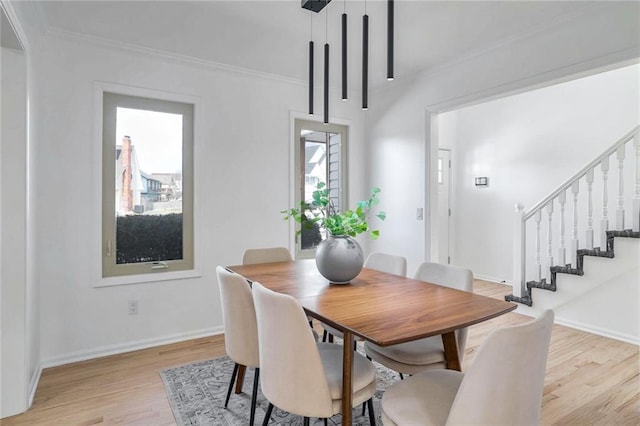 dining room featuring light hardwood / wood-style flooring, crown molding, and a wealth of natural light