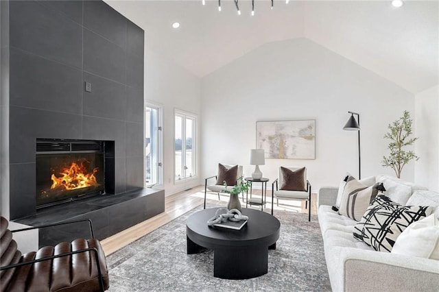 living room featuring light hardwood / wood-style flooring, a fireplace, and vaulted ceiling