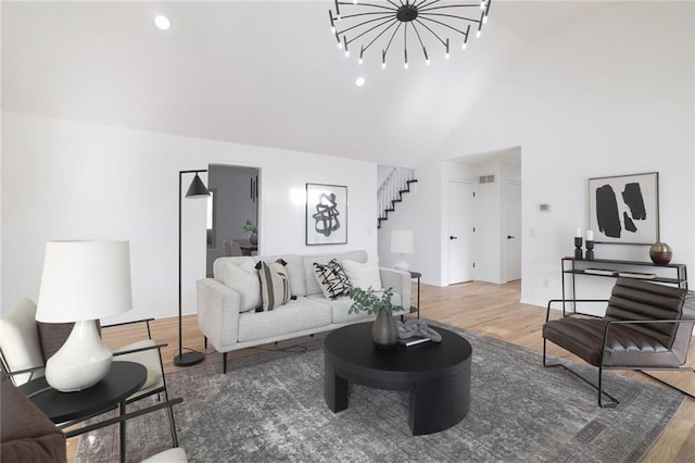 living room with wood-type flooring and high vaulted ceiling