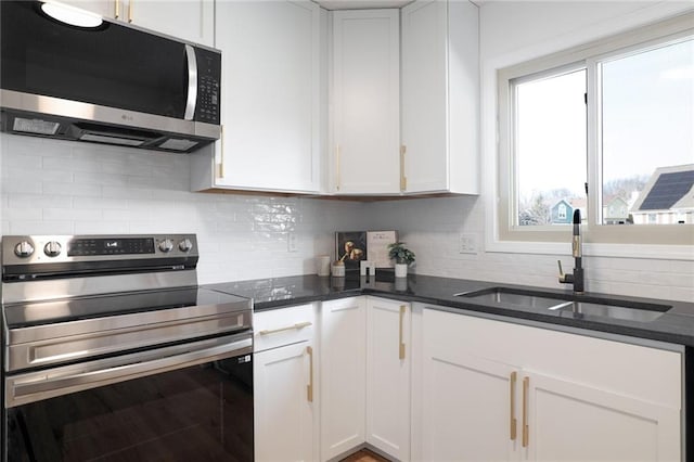 kitchen with white cabinetry, appliances with stainless steel finishes, sink, and decorative backsplash