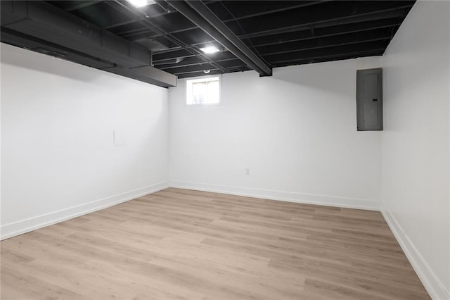 basement with electric panel and light hardwood / wood-style flooring