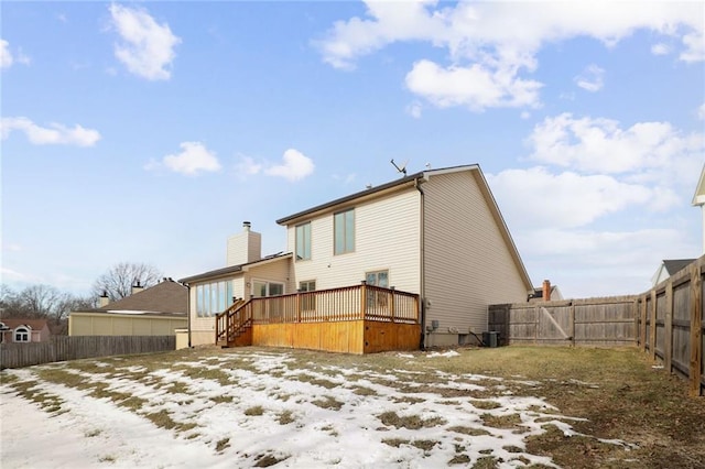 snow covered house with a deck and central air condition unit