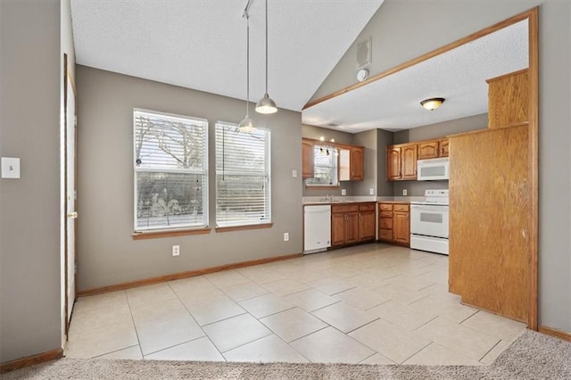 kitchen featuring light tile patterned flooring, white appliances, decorative light fixtures, and sink