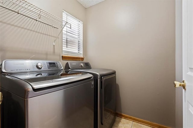 laundry area with light tile patterned floors and washer and dryer