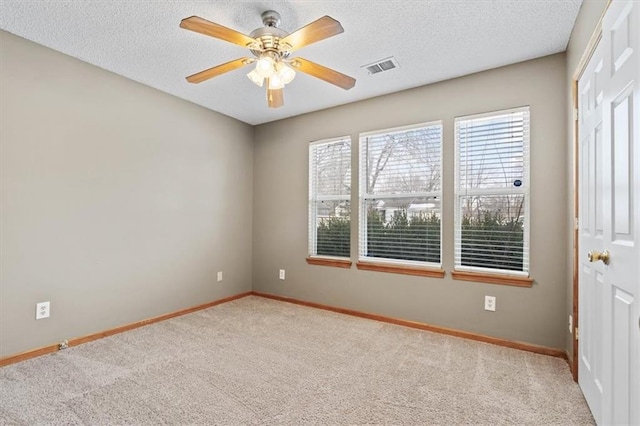 carpeted spare room with ceiling fan and a textured ceiling