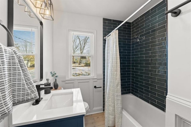 full bathroom featuring vanity, a healthy amount of sunlight, toilet, and shower / bath combo with shower curtain