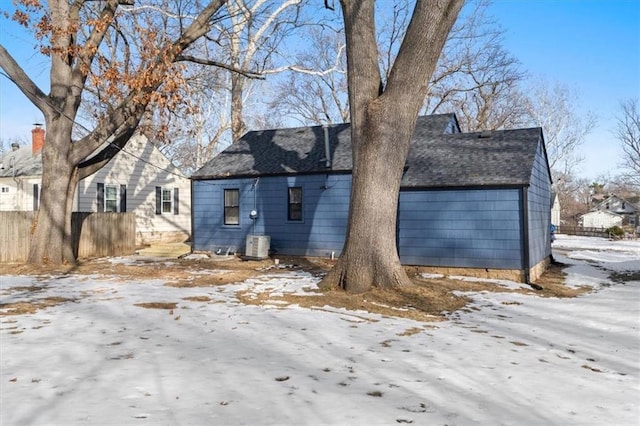 snow covered back of property featuring central AC