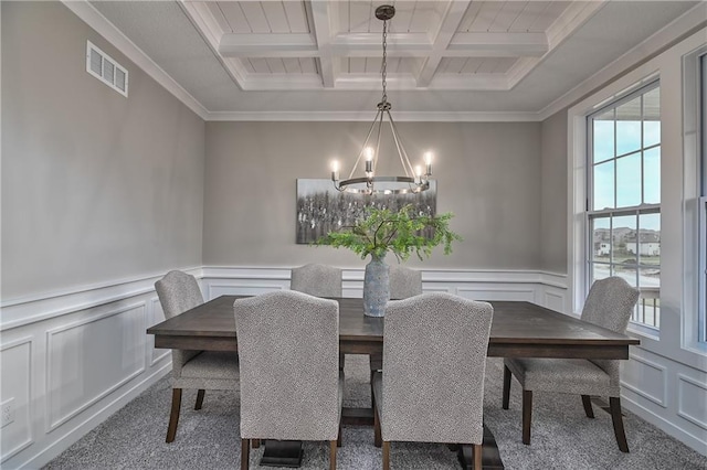 dining room featuring coffered ceiling, crown molding, a chandelier, beam ceiling, and carpet