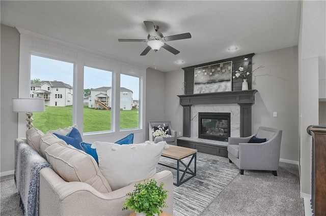 carpeted living room featuring ceiling fan and a high end fireplace