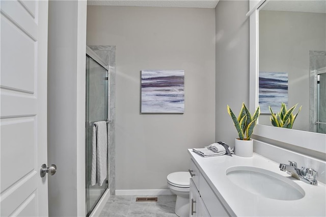 bathroom with vanity, a shower with door, and toilet